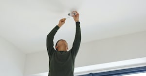 man installing ceiling fan