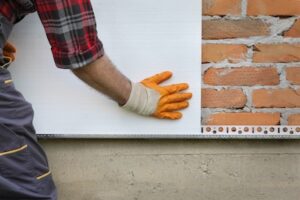 installing insulation to home exterior wall panels